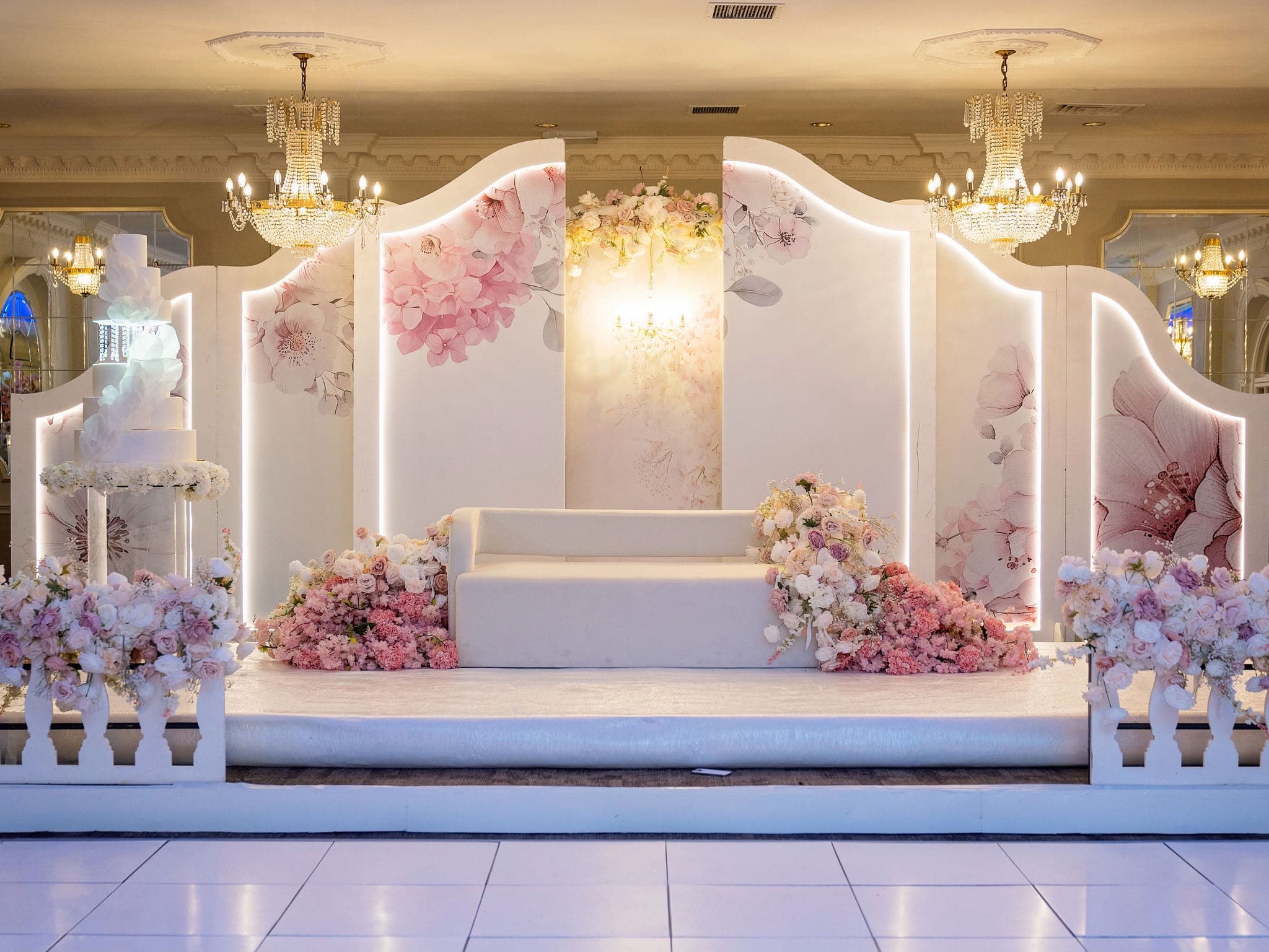 Pink and white floral wedding stage with curved decorative panels