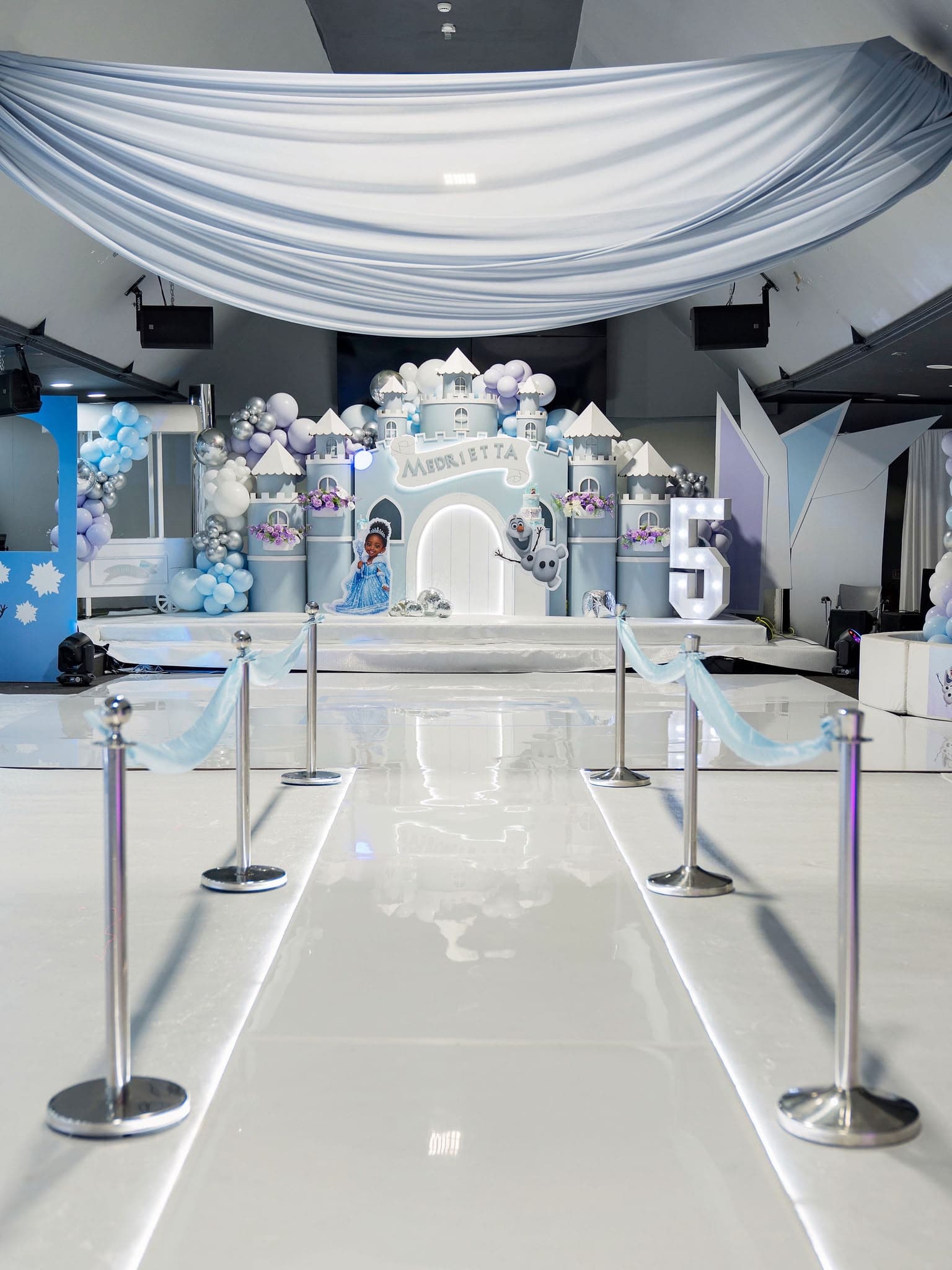Silver and blue entrance walkway leading to a birthday castle