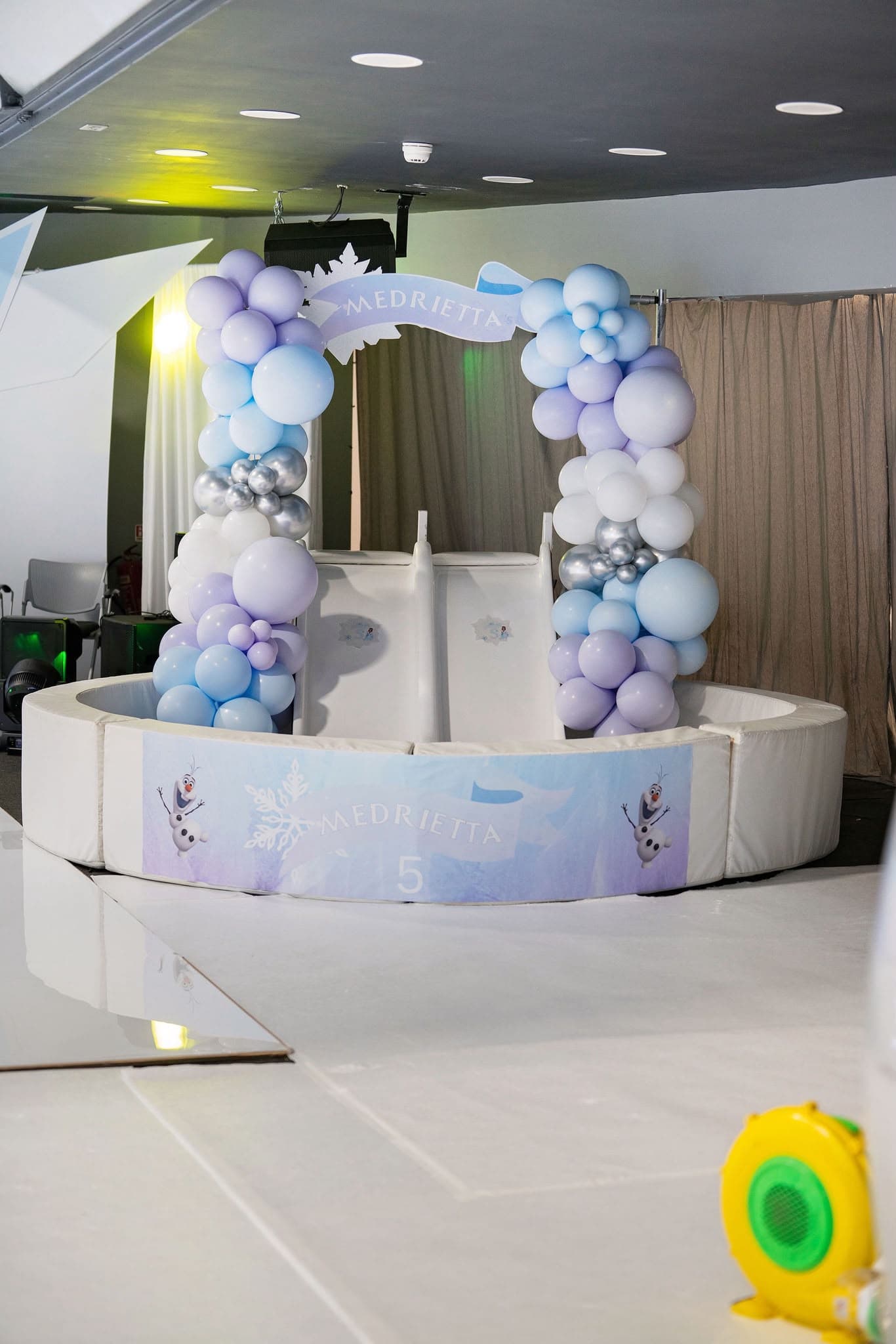 Birthday cake display framed by pastel balloons