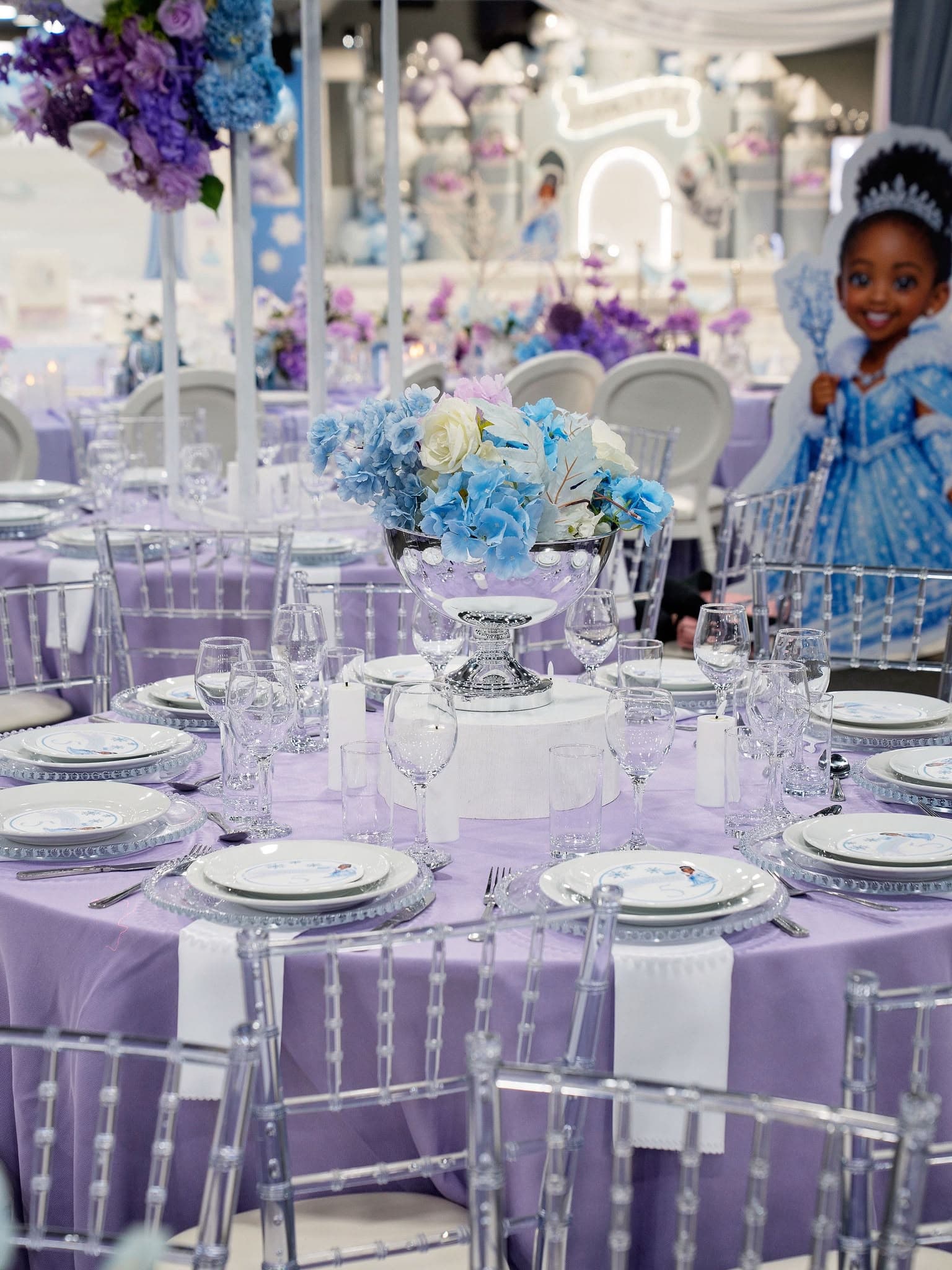 Birthday child at a flower-filled party table