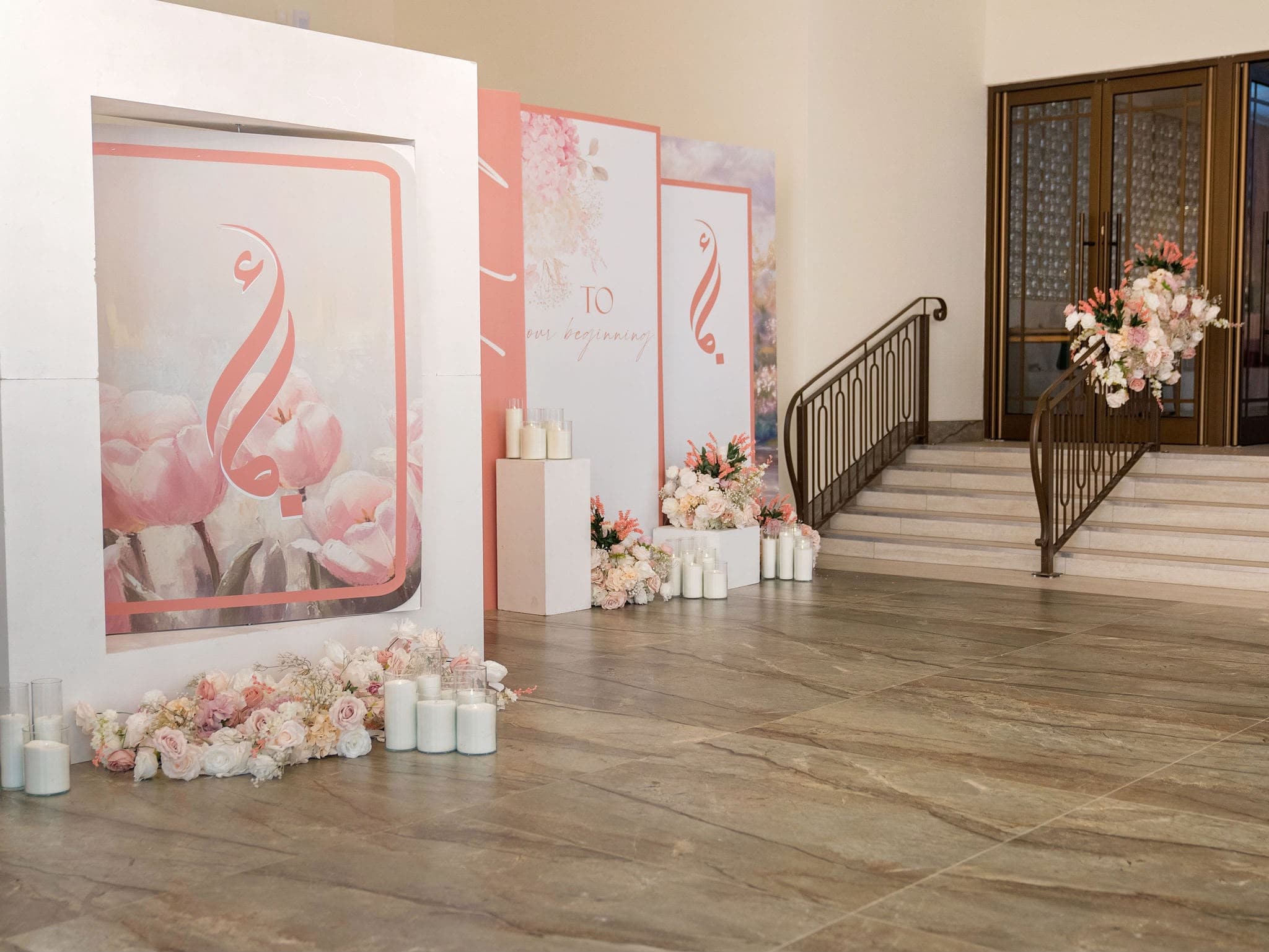 Personalised pink floral welcome panels with candles at a venue entrance